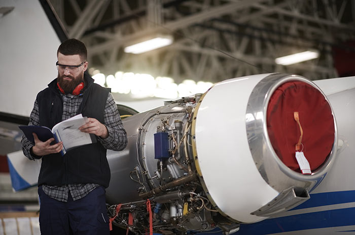 Un homme consulte un rapport à côté d'un avion