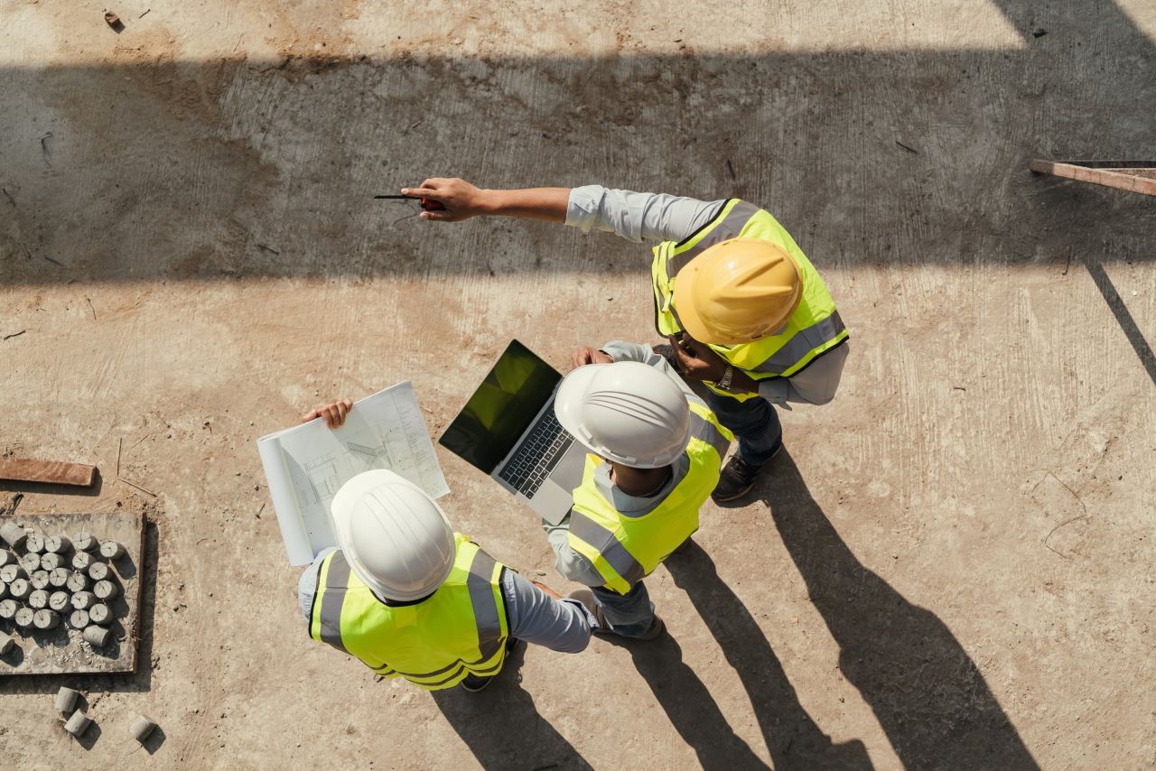 Collaborateurs sur chantier portant des epi et tablette et plan