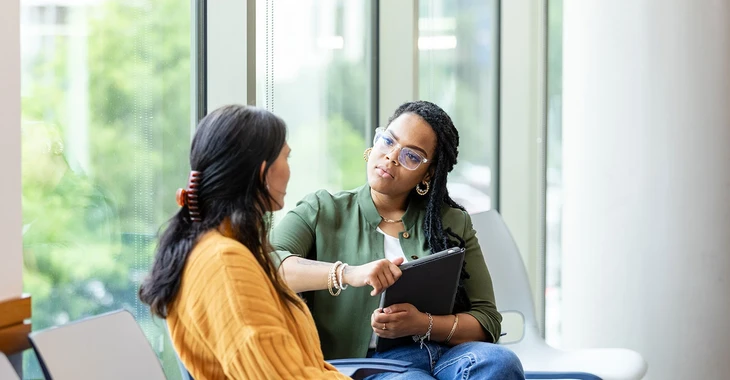 Deux collaboratrices discutent au travail